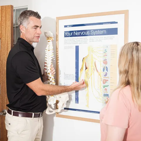 Dr Paul Cater explaining the nervous system to a patient at Palm Beach Chiropractic on the Gold Coast
