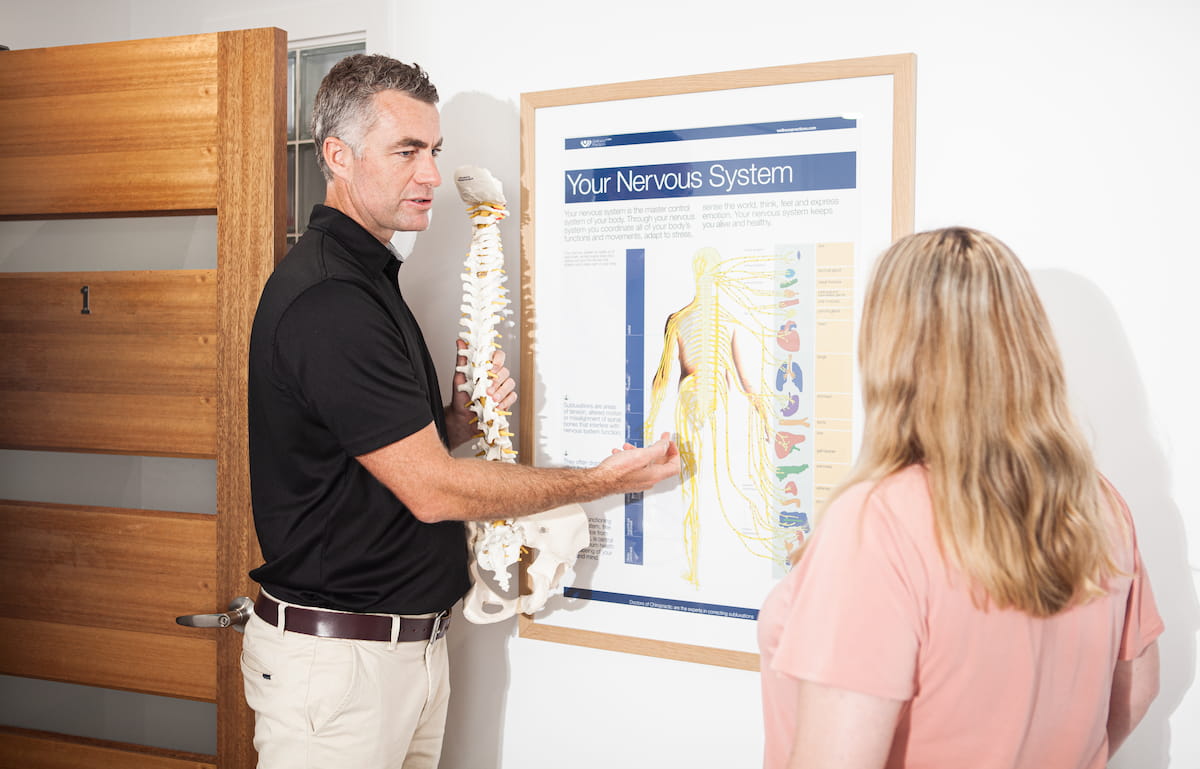 Dr Paul Cater explaining the nervous system to a patient at Palm Beach Chiropractic on the Gold Coast